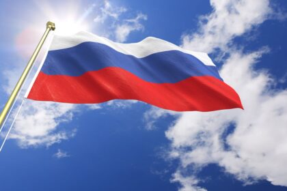 The Russian flag with the sun shining in the background.