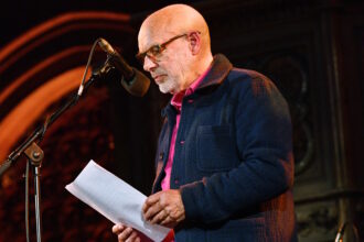 LONDON, ENGLAND - APRIL 18: Brian Eno speaks during SUMUD, a fundraising event for Palestine, organised by the Amos Trust, at Union Chapel on April 18, 2024 in London, England. Sumud, meaning 'steadfast perseverance' in Arabic, is a common term used to describe Palestinian non-violent, resistance against Israel's occupation. Amos Trust is a small, creative human rights organisation who have been working in Palestine for over 30 years with local and international peace activists, partnering with grass-roots projects, campaigning for Palestinian rights. (Photo by Jim Dyson/Getty Images)