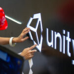 A worker installs Unity logo at Unity Technologies booth one day before the China Digital Entertainment Expo &amp; Conference (ChinaJoy) at Shanghai New International Expo Center on August 1, 2019 in Shanghai, China.