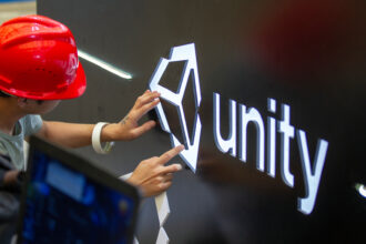A worker installs Unity logo at Unity Technologies booth one day before the China Digital Entertainment Expo &amp; Conference (ChinaJoy) at Shanghai New International Expo Center on August 1, 2019 in Shanghai, China.