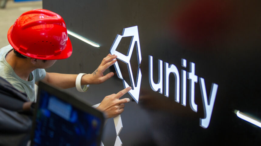 A worker installs Unity logo at Unity Technologies booth one day before the China Digital Entertainment Expo &amp; Conference (ChinaJoy) at Shanghai New International Expo Center on August 1, 2019 in Shanghai, China.