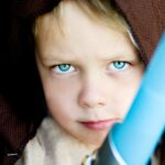 A child poses with a toy lightsabre.