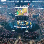 TOPSHOT - Attendees cheer and wave inflatable batons as they watch DRX compete against GEN during the League of Legends Worlds Championship semifinals at State Farm Arena in Atlanta, Georgia on October 30, 2022. (Photo by Elijah Nouvelage / AFP) (Photo by ELIJAH NOUVELAGE/AFP via Getty Images)