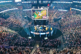 TOPSHOT - Attendees cheer and wave inflatable batons as they watch DRX compete against GEN during the League of Legends Worlds Championship semifinals at State Farm Arena in Atlanta, Georgia on October 30, 2022. (Photo by Elijah Nouvelage / AFP) (Photo by ELIJAH NOUVELAGE/AFP via Getty Images)